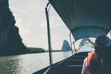 Tourists on long-tailed boat to visit island. (vintage tone)