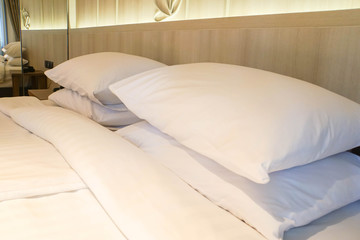 Fototapeta na wymiar close up comfy white pillows on mattress in luxury hotel bedroom
