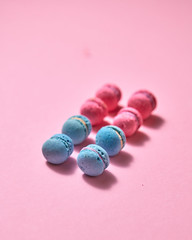 Colorful macaroons in a row on pink background, top view