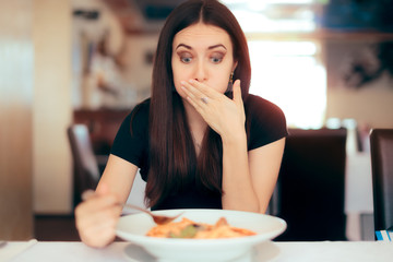 Woman Feeling Sick While Eating Bad Food in a Restaurant - obrazy, fototapety, plakaty