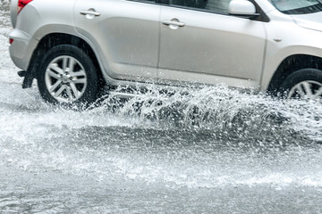 car traffic during rainy day. splashes of water from car wheels