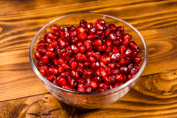 Seeds of the garnet fruit in glass bowl on wooden table