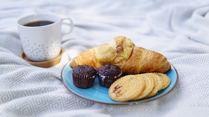 croissants, biscuits and coffee on a picnic overlay