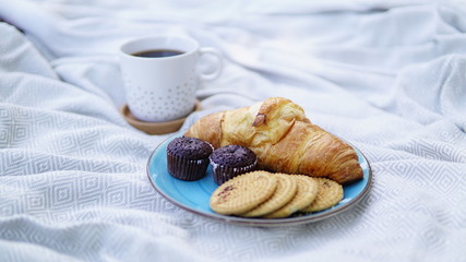 croissants, biscuits and coffee on a picnic overlay