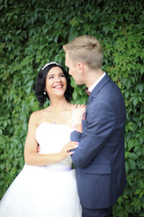 bride and groom on a background of green leaves