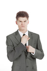 young businessman adjusting his tie.isolated on a white