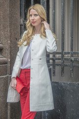 Fashionable young blonde in a spring fashionable suit and with a shopping bag in the center of Moscow
