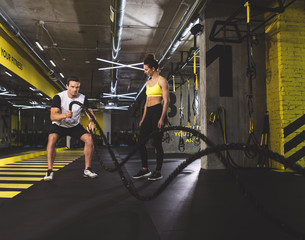Full length portrait of concentrated male doing physical exercise with appliance while standing...