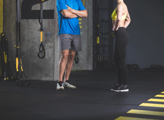 Fototapeta na wymiar Close up male and woman legs standing opposite each other while situating in fitness center. Sport concept