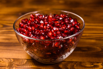 Seeds of the garnet fruit in glass bowl on wooden table