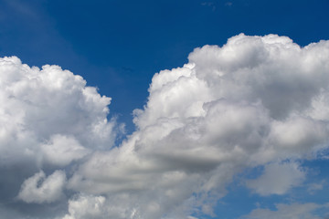Fototapeta na wymiar White fluffy clouds in the blue sky background