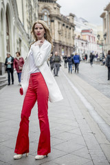 Fashionable young blonde in a spring fashionable suit and with a shopping bag in the center of Moscow
