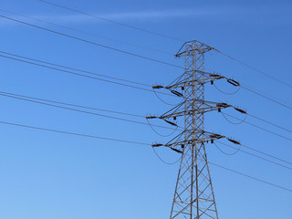 A high-voltage power line illuminated by sunlight against a background of clouds of a stormy sky. Transport of energy over long distances. High technology of modernity.Power industry. Ecology.