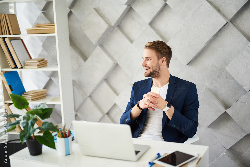 Poster profile of smiling man sitting at table and looking sideways. he is distracted on window view being 