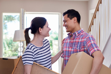 Couple Carrying Boxes Into New Home On Moving Day