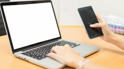 Business woman working on a computer and contacting a job on a smartphone.Business woman working at office with laptop and documents on her desk.business concept.Idea presentation.