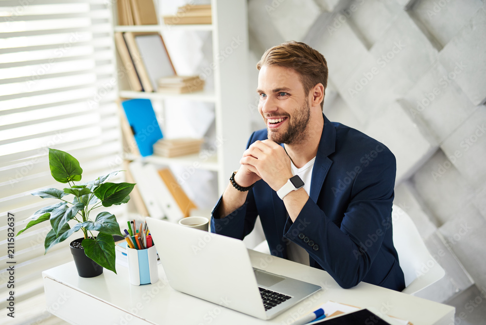 Poster successful deal. side view of happy male leaning against table with elbows. he is looking forward wi