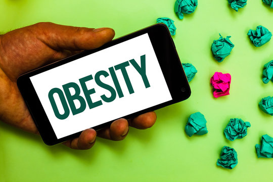 Conceptual hand writing showing Obesity. Business photo text Medical condition Excess of body fat accumulated Health problem Text message smart screen mobile handset crumpled small balls.