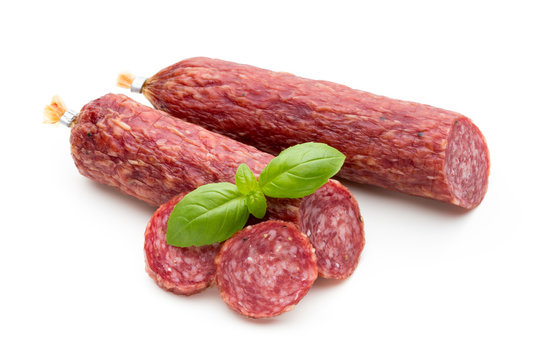 Salami smoked sausage, basil leaves and peppercorns isolated on white background.