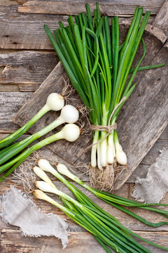 Fresh green onion on  wooden background. Top view.
