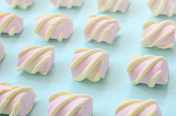 Colorful marshmallow laid out on blue paper background. pastel creative textured pattern....