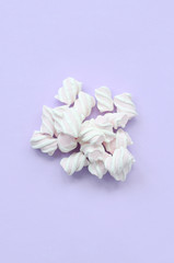 Colorful marshmallow laid out on violet paper background. pastel creative texture. minimal