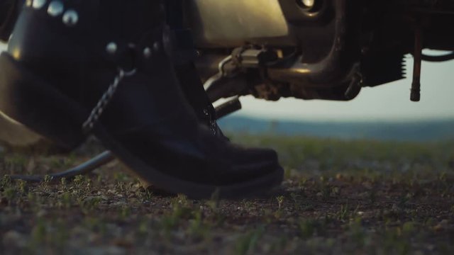 biker, on the background of the sunset, looking into the distance. enthusiast of travelling on a bike