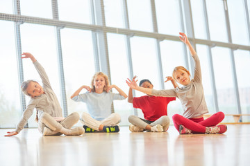 Kinder beim Stretching im Sportunterricht