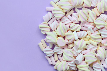 Colorful marshmallow laid out on violet paper background. pastel creative texture. minimal