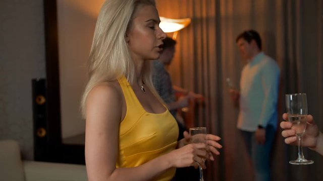 Woman and man communicating in flat apartment party, acquaintance and flirting. They in happiness, smiling, laughing. Hints at the continuation of the evening in an intimate atmosphere. 4k Slow motion