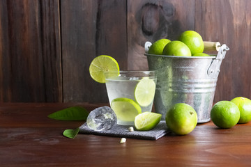 Lime juice or lime lemonade or green lemon with lemon tank on wooden table.