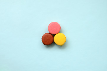 Dessert cake macaron or macaroon on trendy pastel blue background top view. Flat lay composition