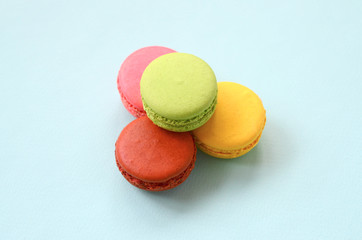 Dessert cake macaron or macaroon on trendy pastel blue background. Fashionable tasty colorful cookies