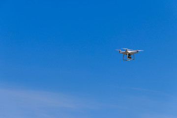 Fototapeta na wymiar Drone with camera flying in blue sky