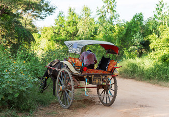 Fototapeta na wymiar A cart on a rural road in Bagan, Myanmar. Copy space for text.