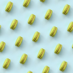 Green dessert cake macaron or macaroon on trendy pastel blue background top view. Flat lay pattern composition
