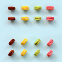 Dessert cake macaron or macaroon on trendy pastel blue background top view. Flat lay composition