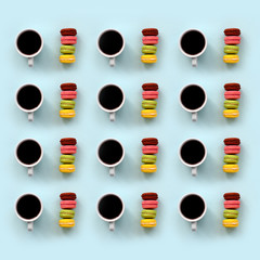 A pattern of many colorful dessert cake macaroon and coffee cups on trendy pastel blue background top view. Flat lay composition