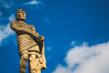 Fototapeta premium Stone statue of a man with cloudy blue sky background