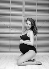 Beautiful pregnant woman is posing on camera. Pregnancy concept.