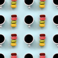 A pattern of many colorful dessert cake macaroon and coffee cups on trendy pastel blue background top view. Flat lay composition