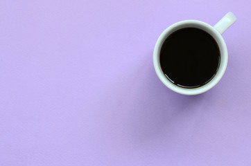 Small white coffee cup on texture background of fashion pastel violet color paper in minimal concept