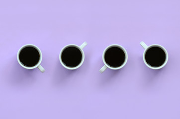 Many small white coffee cups on texture background of fashion pastel violet color paper in minimal concept