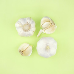 Set composition with heads, halves and slices of garlic, Creative layout on light green background close-up macro, top view.