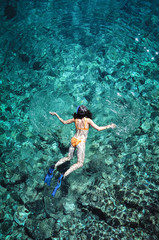 Woman snorkeling in emerald sea water