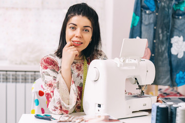 Tailor sewing and sitting in her workshop