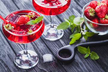 strawberry cocktail with ice and fresh mint on a black wooden table
