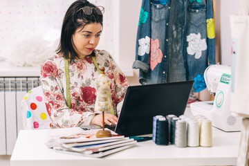 Young entrepreneur woman fashion designer working in her atelier