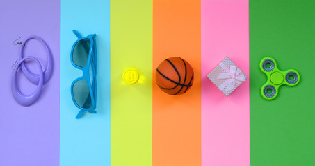 Trendy fashionable pastel composition with earrings, sunglasses, beverage can, basketball ball,...