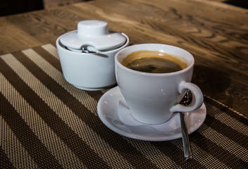 cappuccino coffee in cup and sugar bowl